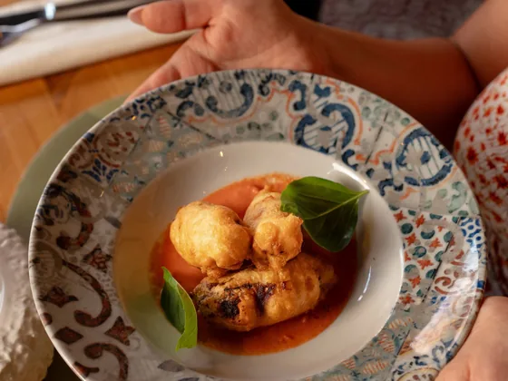 Due fiori di zucca fritti serviti nel piatto con basilico fresco